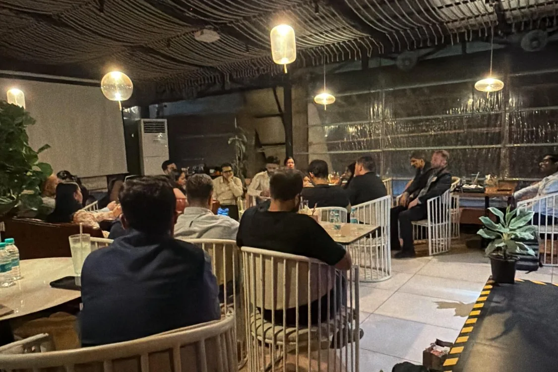 Occupied room at the FoodTech Weekly Roadshow in Mumbai — globe pendants, people at tables